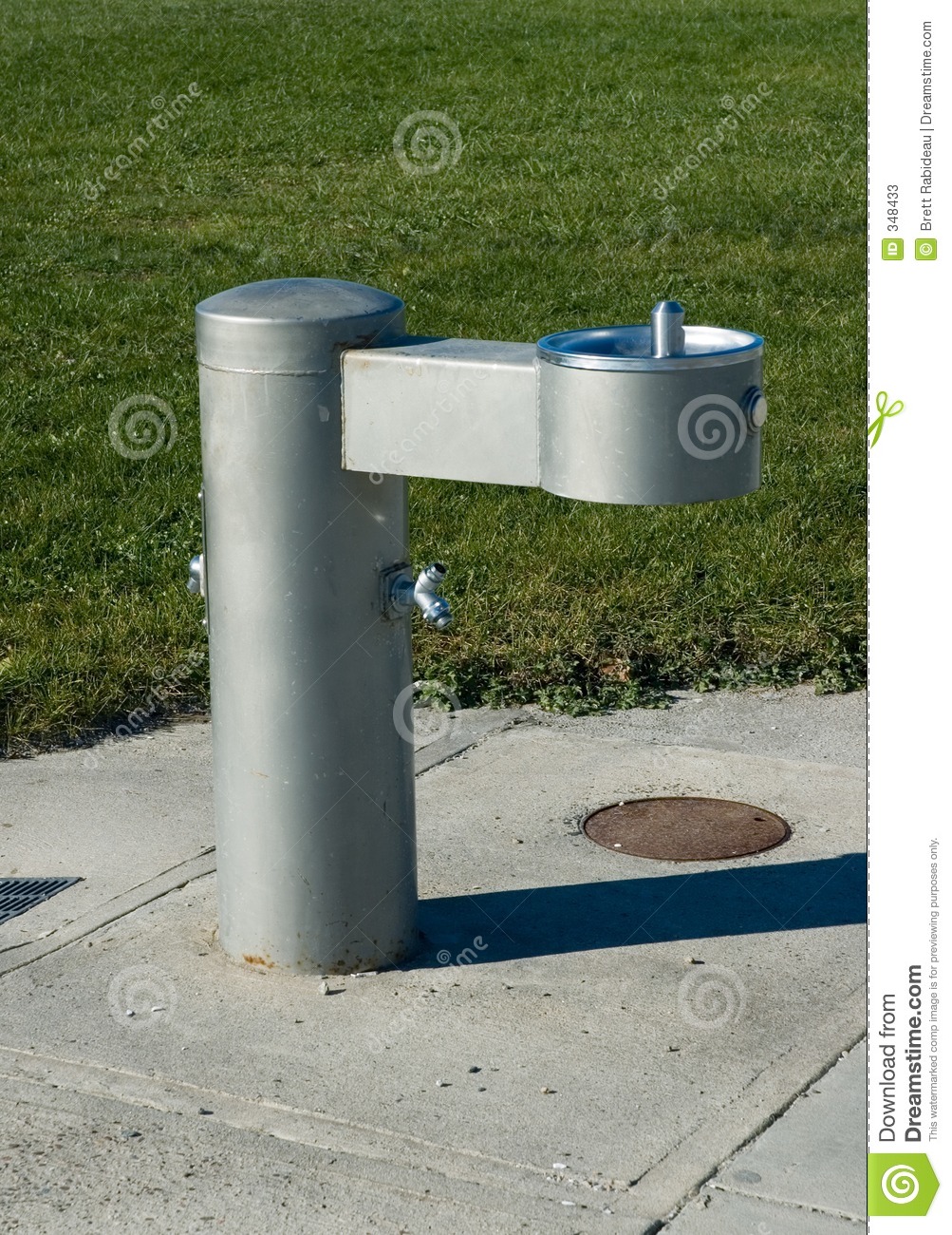 Drinking Fountain In Park Installed In A Sidewalk On The Edge Of The