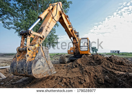 Excavator Digging A Trench On The Site Focus On The Excavator Back