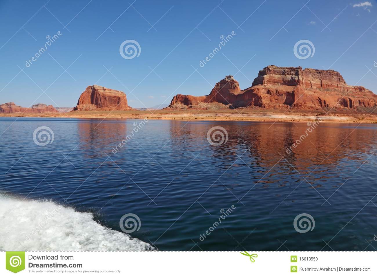 Picturesque Red Cliffs Reflected In The Smooth Water Of The Lake