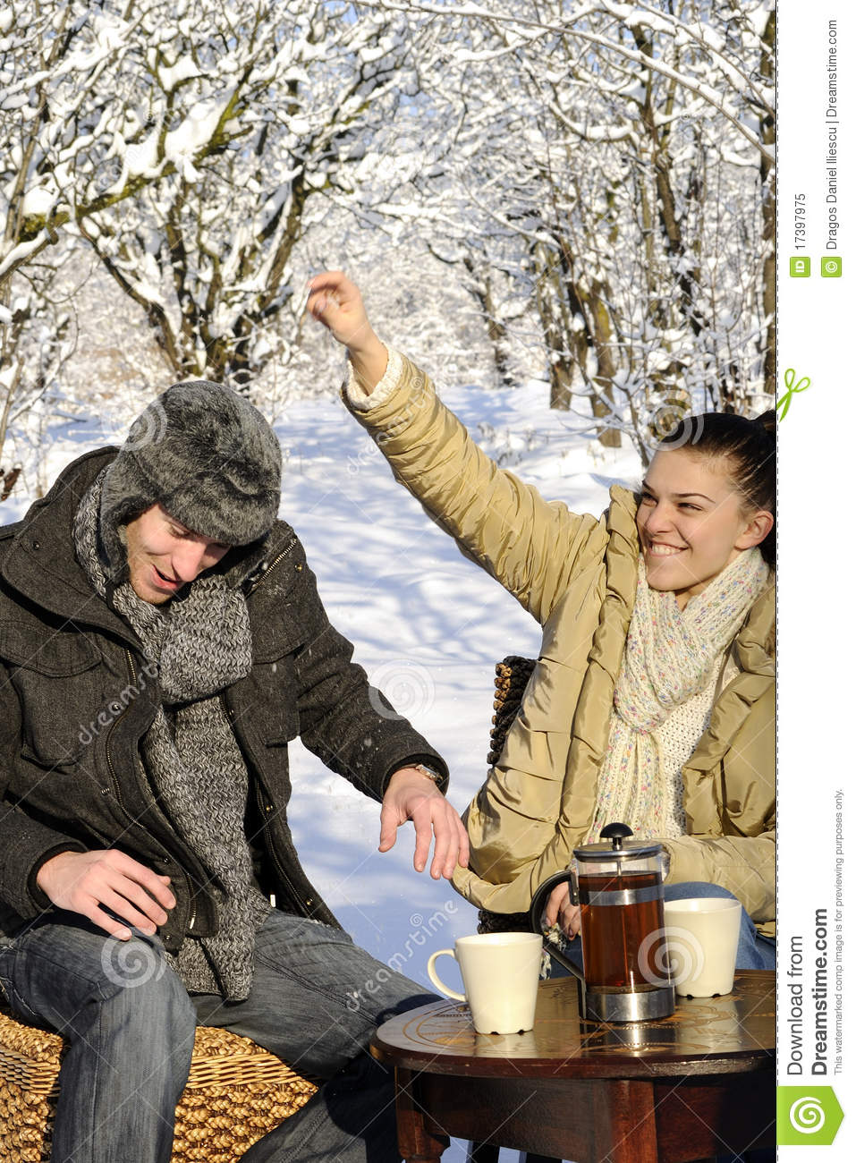 Young Man And Woman Celebrating Winter Season Cups With Tea On Table