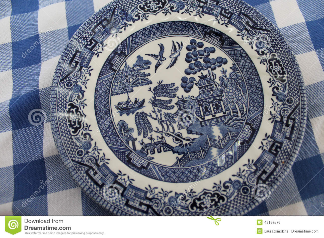 Classic Old Blue Willow China Plate On A Blue And White Tablecloth
